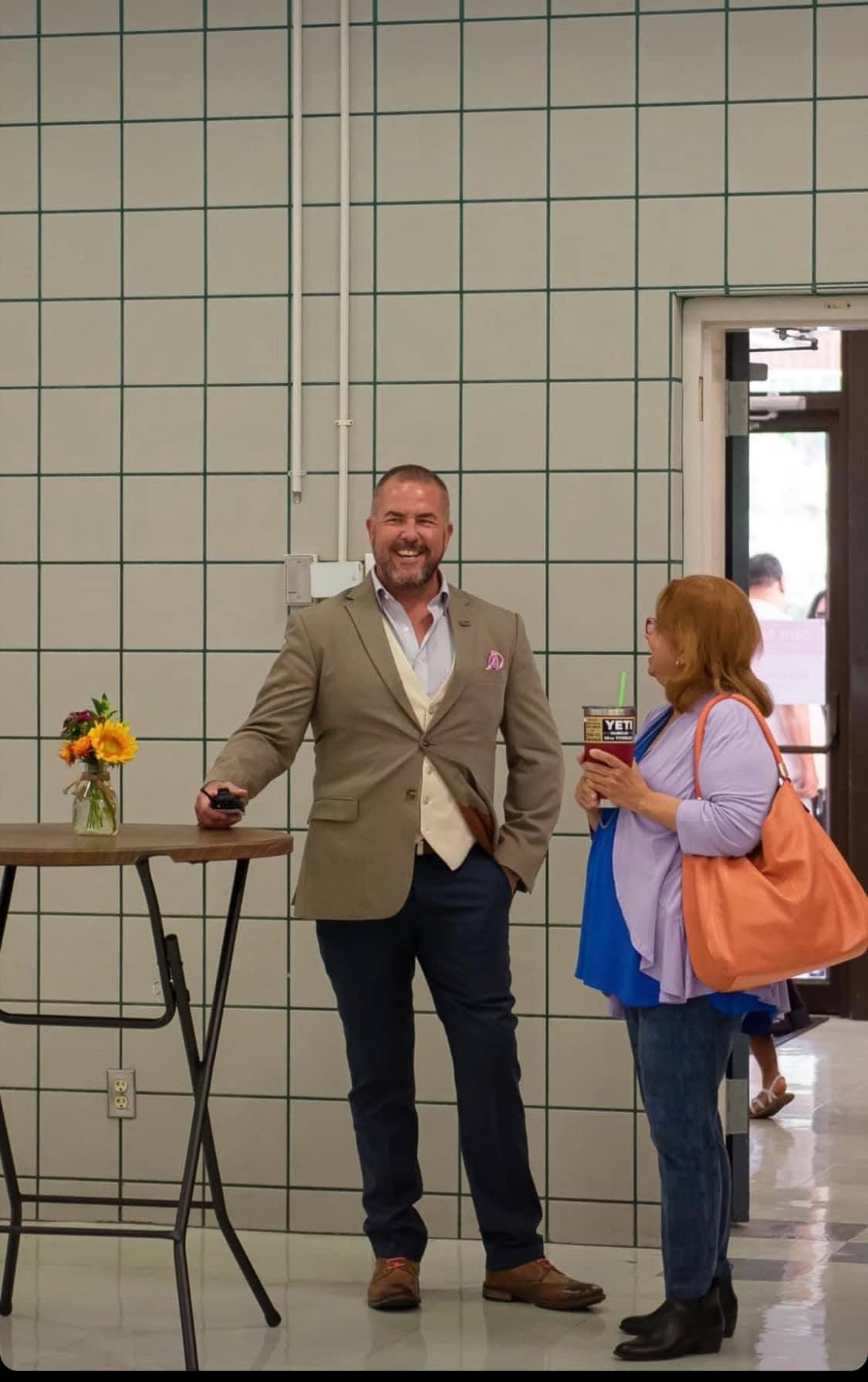Guy Beveridge laughing with an attendee at a community event